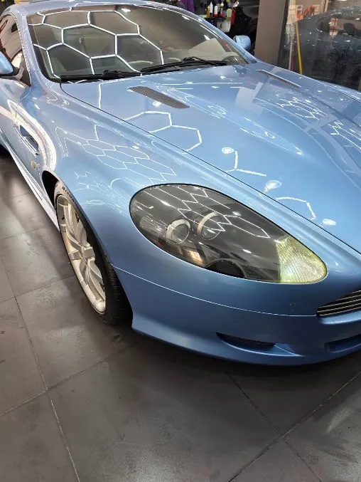 سيارة زرقاء فاتحة تحت إضاءة الاستوديو